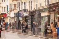 Covid lockdown two: coffee queues, traffic jams, staring at shops and boredom. On a sodden seafront in Hove, East Sussex, walkers look for respite from the latest coronavirus restrictions