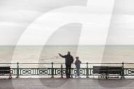 Covid lockdown two: coffee queues, traffic jams, staring at shops and boredom. On a sodden seafront in Hove, East Sussex, walkers look for respite from the latest coronavirus restrictions