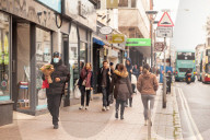 Covid lockdown two: coffee queues, traffic jams, staring at shops and boredom. On a sodden seafront in Hove, East Sussex, walkers look for respite from the latest coronavirus restrictions