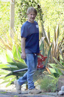 Movie superstar Sean Penn, 60, shows his down-to-earth side and flashes a rare public smile as he is spotted cleaning up his front yard .