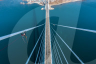 FEATURE -  Arbeiter reinigen Eis von einer 300m hohen Brücke in Wladiwostock