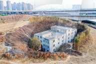 FEATURE - Nagelhaus in Zhengzhou, China, wird durch Bambuszaun geschützt