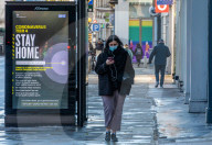 Members of the public walk past a Covid-19 information display as Ministers reveal that the Oxford vaccine could be approved next week.
