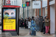 Members of the public walk past a Covid-19 information display as Ministers reveal that the Oxford vaccine could be approved next week.