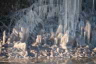 FEATURE - Das gefrorene Wasser aus einer Pfütze verursacht eine bizarre Eisformation am Strassenrand im britischen Headley
