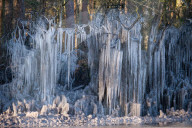 FEATURE - Das gefrorene Wasser aus einer Pfütze verursacht eine bizarre Eisformation am Strassenrand im britischen Headley