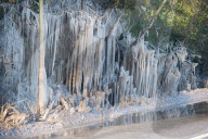 FEATURE - Das gefrorene Wasser aus einer Pfütze verursacht eine bizarre Eisformation am Strassenrand im britischen Headley