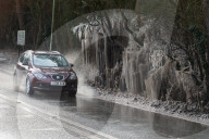 FEATURE - Das gefrorene Wasser aus einer Pfütze verursacht eine bizarre Eisformation am Strassenrand im britischen Headley