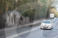 FEATURE - Das gefrorene Wasser aus einer Pfütze verursacht eine bizarre Eisformation am Strassenrand im britischen Headley