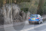FEATURE - Das gefrorene Wasser aus einer Pfütze verursacht eine bizarre Eisformation am Strassenrand im britischen Headley