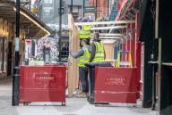 Workmen prepare restaurants and non-essential shops in Covent Garden, London. 