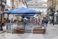 Workmen prepare restaurants and non-essential shops in Covent Garden, London. 