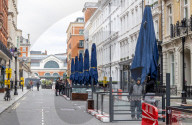 Workmen prepare restaurants and non-essential shops in Covent Garden, London. 