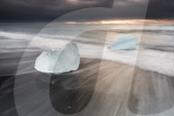 Icebergs at sunrise on Jokulsarlon Beach, a black volcanic sand beach in South East Iceland