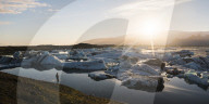 Tourist at Jokulsarlon Glacier Lagoon at sunset, South East Iceland