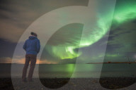 Tourist watching the Northern Lights (Aurora Borealis), Reykjavik, Iceland