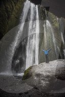 Tourist at the 'hidden' Gljufrabui Waterfall, near Seljalandsfoss, South Iceland (Sudurland)