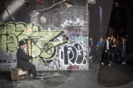 Street performer busking with a fire filled tuba on Clink Street, near Borough Market, Southwark, London, England