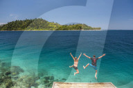 Couple jumping into the Pacific Ocean at Twin Beach, a tropical, white sandy beach near Padang in West Sumatra, Indonesia