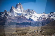 Gauchos riding horses and herding sheep with Mount Fitz Roy behind, El Chalten, Patagonia, Argentina