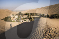 Climbing sand dunes at sunset at Huacachina, a village in the desert, Ica Region, Peru
