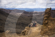 Couple resting on the Tongariro Alpine Crossing, Tongariro National Park, North Island, New Zealand