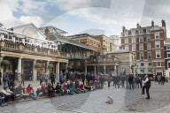 Juggler performs to a large crowd, Piazza and Central Market, Covent Garden, London, United Kingdom