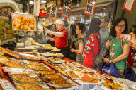 Customers queue at busy local Japanese teriyaki food stall, Nishiki Market (Kyoto's Kitchen), Downtown Kyoto, Japan