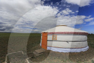 Tourist ger amidst expansive Gobi landscape under a blue sky, Gurvan Saikhan National Park, Tsagaan Tolgol, Mongolia