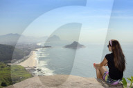 A young hiker looking out from the viewpoint over Pontal and Recreio dos Bandeirantes beaches in Barra da Tijuca, Rio