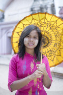 A local girl with a traditional paper sunshade umbrella and thanaka face paint