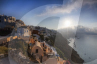 Sunbeam through the clouds over the Aegean Sea seen from the typical village of Oia Santorini Cyclades Greece Europe