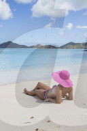 Lady on the sand surrounded by turquoise Caribbean Sea, Ffryes Beach, Sheer Rocks, Antigua and Barbuda, Leeward Islands, West Indies, Caribbean, Central America