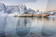The colors of dawn frame the fishermen's houses surrounded by snowy peaks, Sakrisoy, Reine, Nordland, Lofoten Islands, Arctic, Norway, Scandinavia, Europe