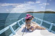 A tourist admires the colors of Caribbean Sea from a boat, Green Island, Antigua and Barbuda, Leeward Islands, West Indies, Caribbean, Central America