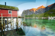 Typical house of fishermen called Rorbu lit up by midnight sun, Reine, Nordland county, Lofoten Islands, Arctic, Northern Norway, Scandinavia, Europe