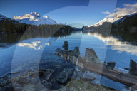 Dawn illuminates the snowy peaks reflected in the calm waters of Lake Sils Engadine Canton of GraubÃ¼nden Switzerland Europe