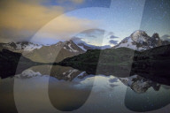 The stars illuminate the snowy peaks and reflected in Lac de Cheserys Chamonix Haute Savoie France Europe