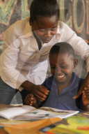 ISINGIZWE Alice 8 years old who is dumb and her teacher MUSABYEMARIYA Alphonsine from Ngwino Nawe, the village for children with disability, teaching Alice how to read a book using signs. Ngwino nawe works with VSO, an international non-governmental organ