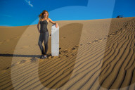 Woman sand boarding on sand dune, Huacachina Oasis, Peru