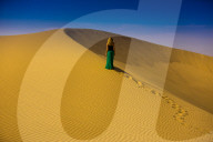 Woman standing on sand dune, Huacachina Oasis, Peru