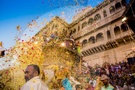 Crowd throwing flower petals during the Flower Holi Festival, Vrindavan, India