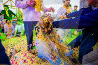 Guru getting flower petals smashed in his face during the Flower Holi Festival, Vrindavan, India