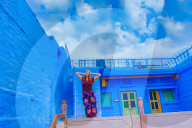 Woman stands on the blue rooftop of Rani Mahal Hotel, in Jodhpur, the Blue City, Rajasthan, India