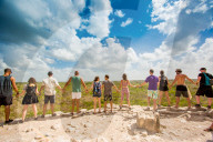 Group of people hold hands at the summit of Nohoch Mul Pyramid in the Ancient Mayan City of Coba, outside Tulum, Mexico, North America