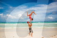 Acrobatic couple balancing together on the beach of Tulum, Mexico, North America