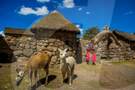 Woman standing at her home in Llacon, Lake Titicaca, Peru