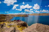 Two people sitting on the edge of Lake Titicaca, Peru