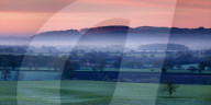 Dawn illuminates Beeston and Peckforton castles on the Peckforton sandstone ridge with mist lying on the Cheshire plain below, Cheshire, England, United Kingdom, Europe