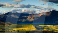 The plains and lakes of Otago region framed by cloud capped mountains, Otago, South Island, New Zealand, Pacific